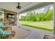 Covered patio with stone fireplace, TV, ceiling fan, and an outdoor view of a green lawn and wooded area at 155 Boxelder Rd, Clover, SC 29710