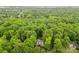 A charming home nestled amongst a vibrant, dense forest captured from above at 1669 Mary Ellen Dr, Fort Mill, SC 29708