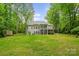 Spacious backyard featuring a well-maintained lawn, mature trees, and a screened-in porch for outdoor living at 1669 Mary Ellen Dr, Fort Mill, SC 29708