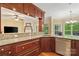 Wet bar with wood cabinets, granite counters, stainless sink and view to breakfast room at 1669 Mary Ellen Dr, Fort Mill, SC 29708