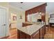 Wet bar with wood cabinets, granite counters, sink, and view to the living room fireplace at 1669 Mary Ellen Dr, Fort Mill, SC 29708