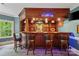 Custom-built bar area with wood finishes, recessed lighting, bar stool seating and a television at 1669 Mary Ellen Dr, Fort Mill, SC 29708