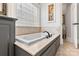 Bathroom with white built-in tub with black faucet, tile surround, and natural light from window at 1669 Mary Ellen Dr, Fort Mill, SC 29708