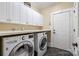 Well-equipped laundry room with front-load washer and dryer, white cabinets, and a countertop for folding at 1669 Mary Ellen Dr, Fort Mill, SC 29708