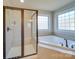 This spacious bathroom features a glass door shower and separate soaking tub with lots of natural light at 1708 Aringill Ln, Matthews, NC 28104