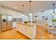 Spacious kitchen with an island featuring granite countertops, white cabinetry and stainless steel refrigerator at 1708 Aringill Ln, Matthews, NC 28104