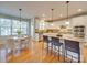 White kitchen with a granite island, stainless appliances, eat in table and pendant lights at 1708 Aringill Ln, Matthews, NC 28104