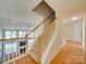 Bright foyer staircase with wooden handrail and carpeted steps, offering a warm welcome to the home at 1708 Aringill Ln, Matthews, NC 28104