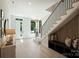 Bright entryway features a staircase with black railings, bench seating, and light wood floors at 1711 Summey Ave, Charlotte, NC 28205