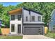 Modern two-story home with a gray exterior, a two-car garage and manicured landscaping at 1711 Summey Ave, Charlotte, NC 28205