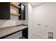 Well-organized laundry room with cabinets, countertops, and tiled floors at 1711 Summey Ave, Charlotte, NC 28205