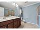 This bathroom features a double sink vanity and shower with tan tiled walls at 17916 Ragtop Day Ln, Cornelius, NC 28031