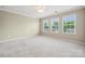 Bright bedroom featuring neutral tones, plush carpet, ceiling fan, and plenty of natural light at 17916 Ragtop Day Ln, Cornelius, NC 28031