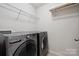 Convenient laundry room with modern washer and dryer units and shelving at 17916 Ragtop Day Ln, Cornelius, NC 28031