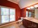 Bright bathroom featuring cherry cabinets, tile flooring and a large window at 200 Waterby Way, Matthews, NC 28104