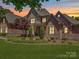 Beautiful brick home featuring a manicured lawn, mature landscaping, and a welcoming front porch at 200 Waterby Way, Matthews, NC 28104