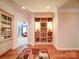 Hallway with hardwood floors, custom built-in shelves, and decorative accents at 200 Waterby Way, Matthews, NC 28104