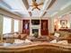 Cozy living room with a fireplace, built-in shelves, coffered ceiling, and comfortable leather seating at 200 Waterby Way, Matthews, NC 28104