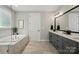 Spa bathroom features double vanity, large mirror and a soaking tub with a frameless glass shower at 2062 Nellies Way, Fort Mill, SC 29715