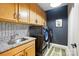 Functional laundry room with stainless steel sink, washer and dryer with stylish wallpaper at 2062 Nellies Way, Fort Mill, SC 29715