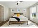 Bright main bedroom featuring a rustic wood bed frame, white rug, and natural light from three windows at 2062 Nellies Way, Fort Mill, SC 29715