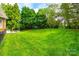 Lush backyard featuring a well-maintained lawn, mature trees, and a stone patio, perfect for outdoor enjoyment at 208 Mcduffie Ln, Fort Mill, SC 29715
