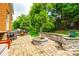 Paver patio with built-in fire pit, lush landscaping, outdoor kitchen and dining areas at 208 Mcduffie Ln, Fort Mill, SC 29715