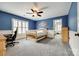 Blue bedroom offering neutral carpet, white wainscotting, ceiling fan, and a light-filled room at 208 Mcduffie Ln, Fort Mill, SC 29715