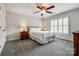 A comfortable bedroom with carpet floors, a ceiling fan, plantation shutters, and two bedside tables at 208 Mcduffie Ln, Fort Mill, SC 29715