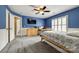 Blue bedroom features neutral carpet, ceiling fan, white wainscotting, and light-filled windows at 208 Mcduffie Ln, Fort Mill, SC 29715