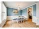 Dining room with large windows, white table, blue chairs and stylish light fixture at 208 Mcduffie Ln, Fort Mill, SC 29715