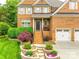 Charming brick two-story home with a well-manicured lawn and a two-car garage at 208 Mcduffie Ln, Fort Mill, SC 29715