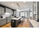 Open kitchen boasts gray cabinets, island with seating, quartz counters, modern lighting, and a breakfast nook at 208 Mcduffie Ln, Fort Mill, SC 29715