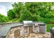 Stone outdoor kitchen featuring a built-in grill, stainless steel appliances, and countertop space at 208 Mcduffie Ln, Fort Mill, SC 29715