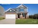 Charming two-story home featuring a two-car garage, stone accents, and a neatly manicured front lawn at 227 Paige Rd, Kings Mountain, NC 28086