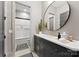 Bathroom features a stylish vanity, round mirror, modern fixtures and access to shower-tub with tiled walls at 2288 Brawley School Rd, Mooresville, NC 28117
