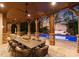 Covered patio with an outdoor dining area, lake views, and a swimming pool at sunset at 2288 Brawley School Rd, Mooresville, NC 28117