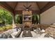 Outdoor living area with stone fireplace and TV, comfortable seating and ceiling fan at 2288 Brawley School Rd, Mooresville, NC 28117