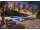 Inviting pool and spa area with lounge chairs and stone accents at twilight at 2288 Brawley School Rd, Mooresville, NC 28117