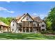 Sprawling lawn leads to a luxury home with a pool, covered porch, and outdoor living spaces at 2288 Brawley School Rd, Mooresville, NC 28117