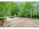 Backyard pool is surrounded by a wooden deck with lush greenery in the background at 2330 Raven Dr, Rock Hill, SC 29732