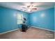 Blue bedroom with a ceiling fan, window, and an elliptical machine at 2330 Raven Dr, Rock Hill, SC 29732