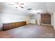 Expansive bonus room with exposed brick, built-in storage, and neutral carpet at 2330 Raven Dr, Rock Hill, SC 29732