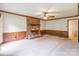 Spacious living room featuring a brick fireplace, wood paneling, and a ceiling fan for a cozy atmosphere at 2330 Raven Dr, Rock Hill, SC 29732