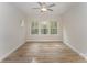 Sunlit bedroom featuring a ceiling fan and large windows overlooking a lush, green outdoor space at 2818 Old Steele Creek Rd, Charlotte, NC 28208