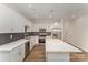 This eat-in kitchen features white cabinetry, stainless steel appliances, a center island, and a decorative tile backsplash at 2818 Old Steele Creek Rd, Charlotte, NC 28208