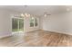 Open living room with sliding glass doors, big windows, and luxury vinyl plank flooring at 2818 Old Steele Creek Rd, Charlotte, NC 28208