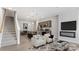 Open-concept living room with modern fireplace, luxury vinyl plank flooring, and an adjacent kitchen with an island at 2918 Sloan Dr, Charlotte, NC 28208