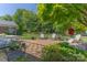 Lush backyard featuring a stone patio, seating area, and mature landscaping, perfect for outdoor entertaining at 3008 Imperial Dr, Gastonia, NC 28054