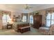 Charming main bedroom boasts a wooden bed frame, floral curtains, ample natural light, and a cozy sitting area with a plaid chair at 3008 Imperial Dr, Gastonia, NC 28054